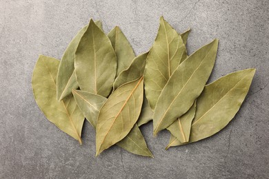 Photo of Aromatic bay leaves on light gray table, top view