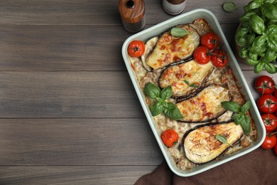 Photo of Delicious eggplant lasagna in baking dish on wooden table, flat lay. Space for text