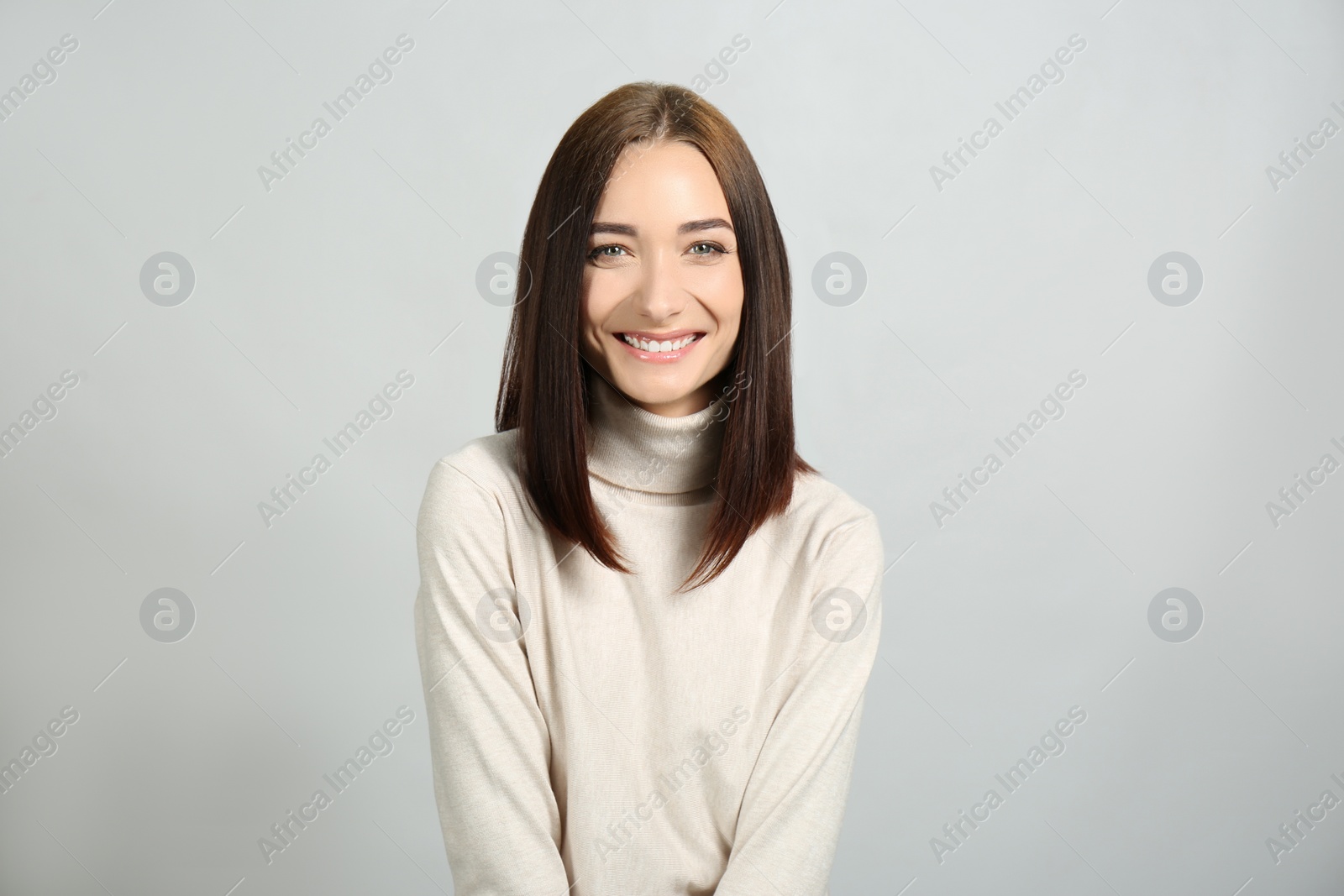 Photo of Portrait of pretty young woman with gorgeous chestnut hair and charming smile on light background