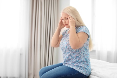 Mature woman suffering from headache at home