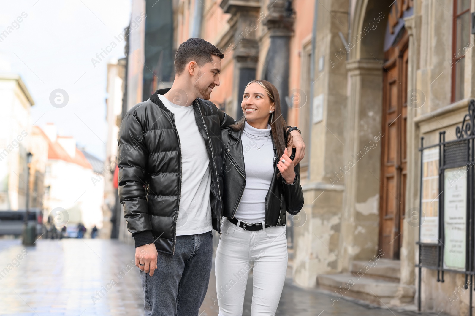 Photo of Lovely young couple walking together on city street. Romantic date