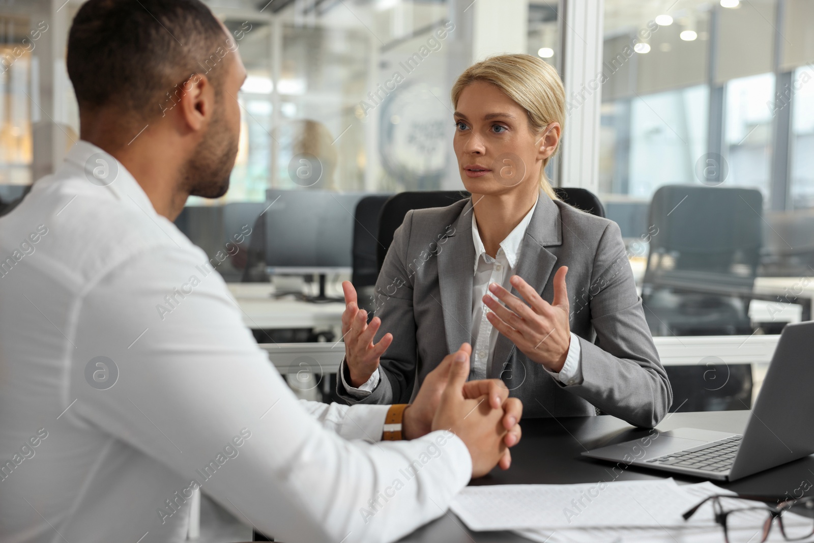 Photo of Lawyer working with client at table in office