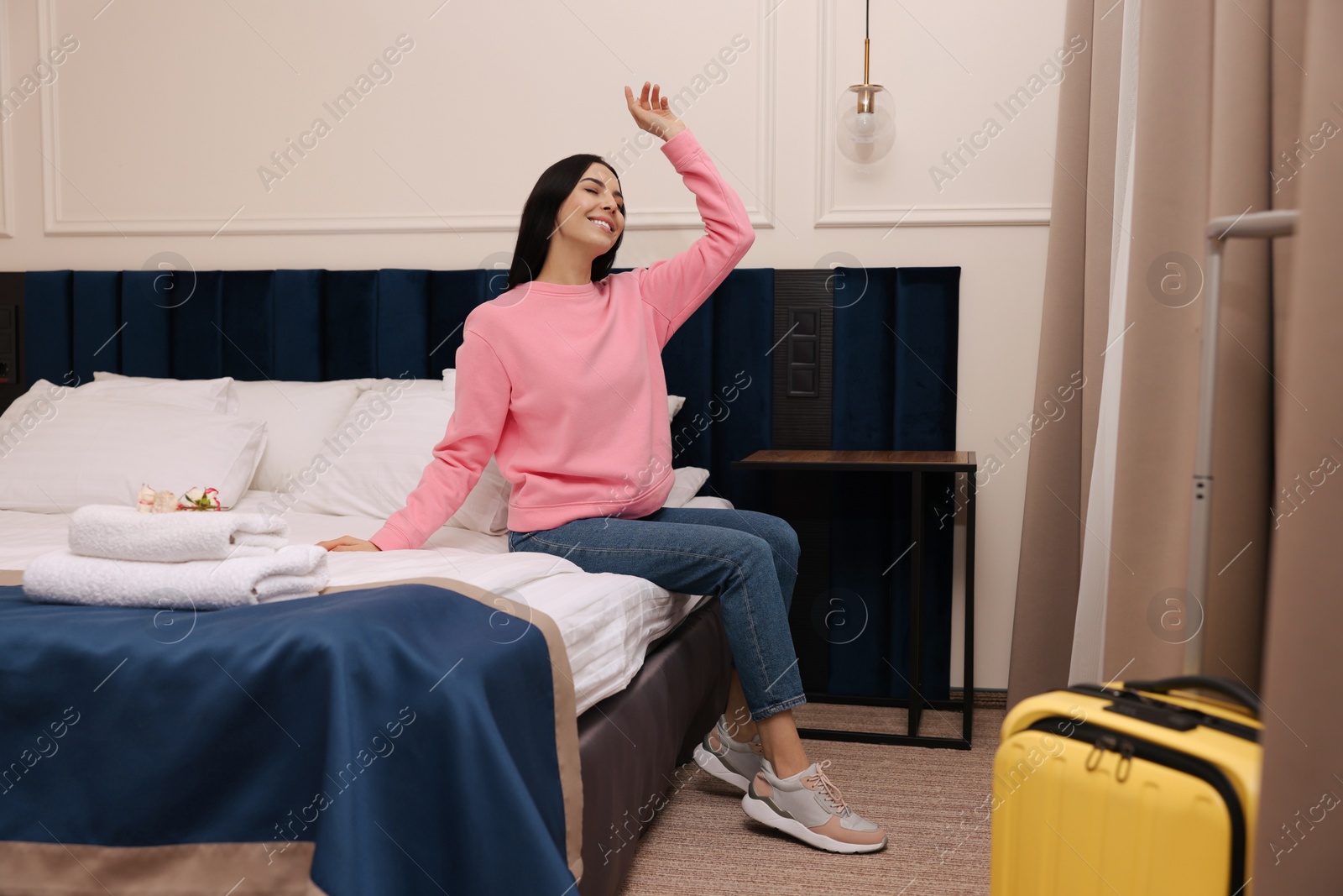 Photo of Beautiful young woman relaxing on bed in hotel room