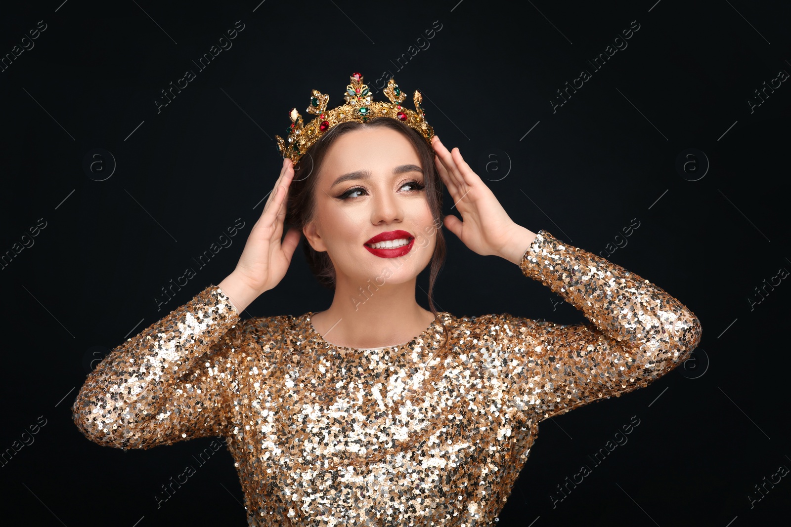 Photo of Beautiful young woman wearing luxurious crown on black background