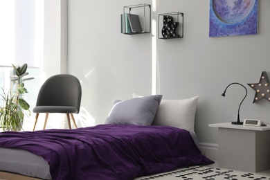 Modern teenager's room interior with comfortable bed and stylish design elements