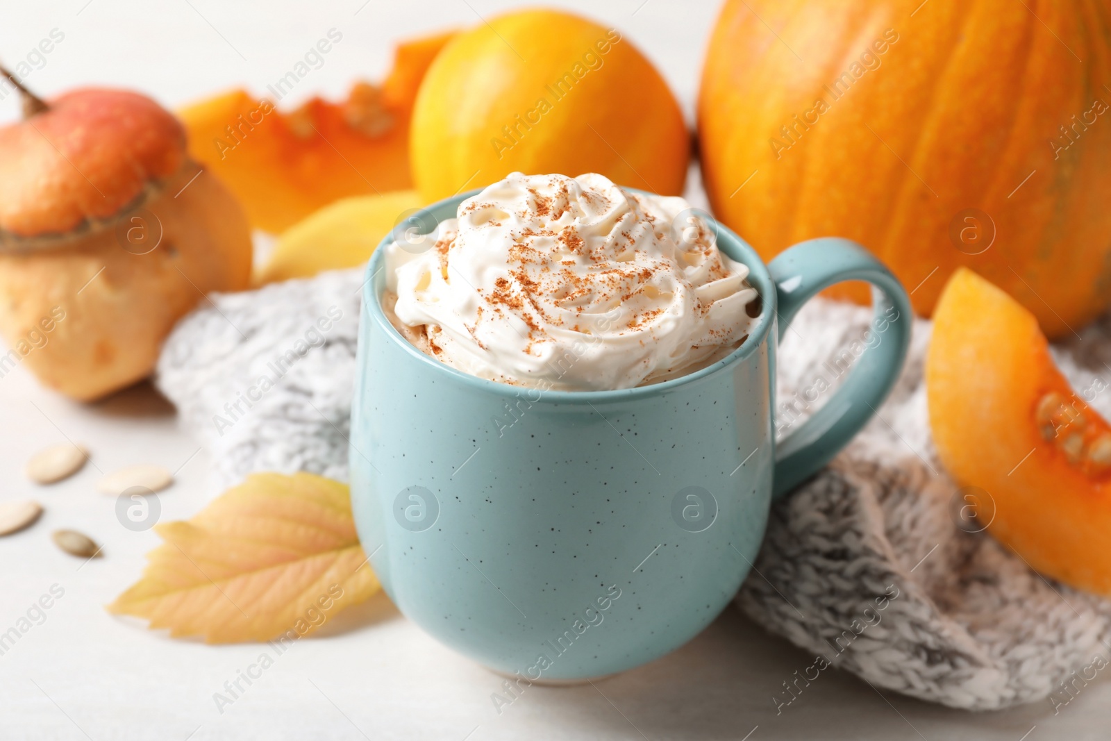 Photo of Cup with tasty pumpkin spice latte on light table