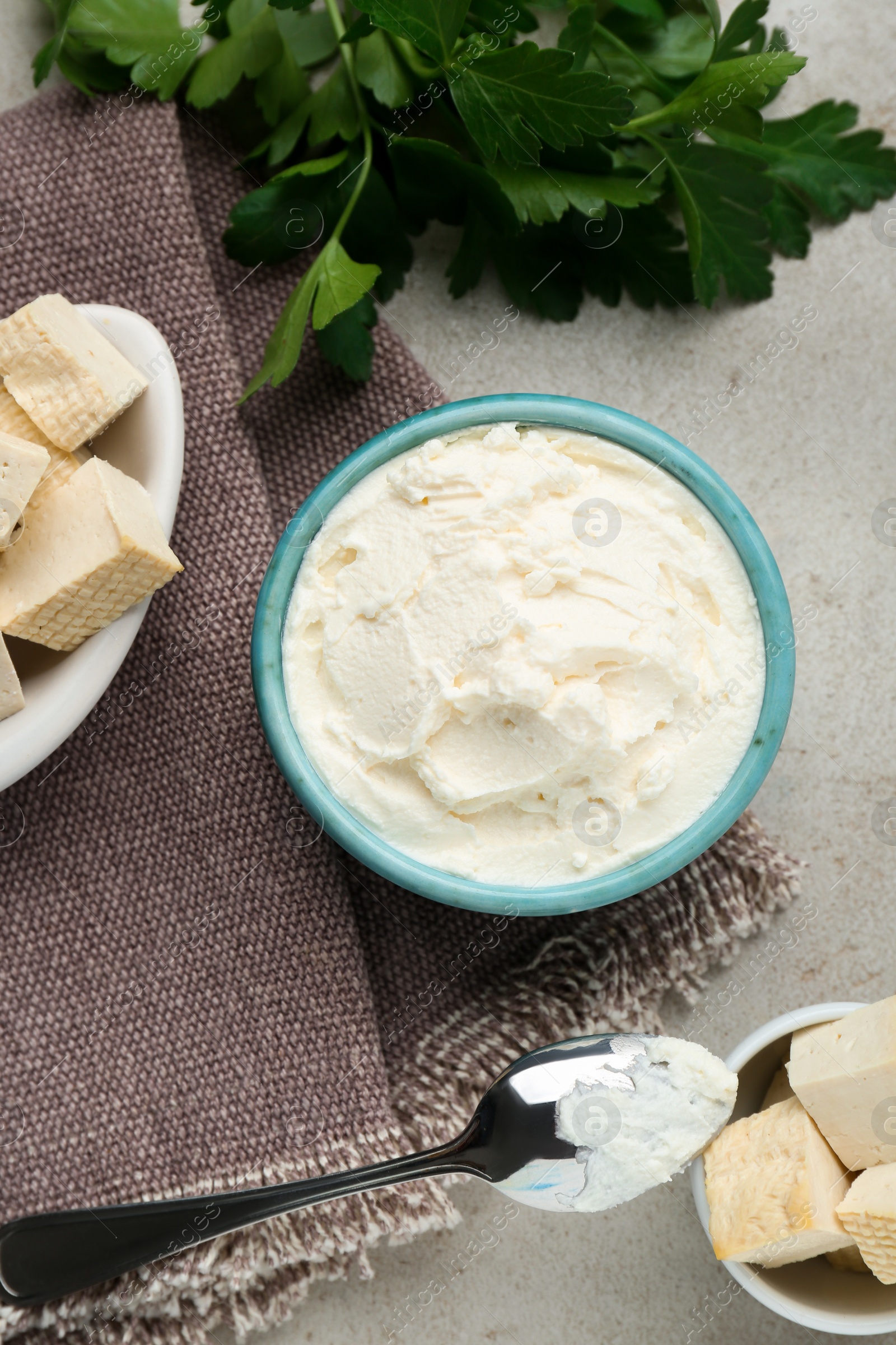 Photo of Delicious tofu cheese and spoon on light table, flat lay