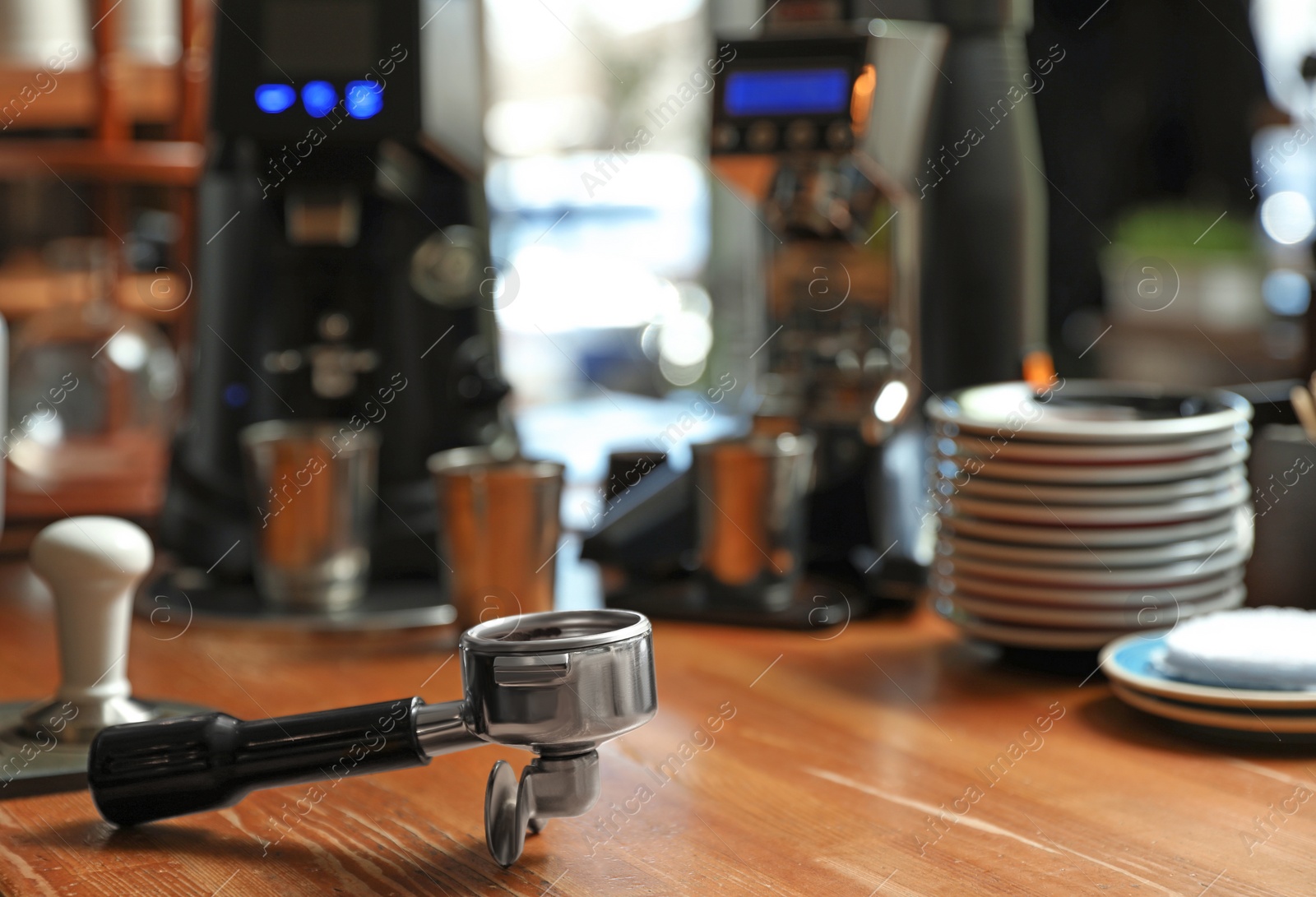 Photo of Portafilter with milled coffee on wooden bar counter. Space for text