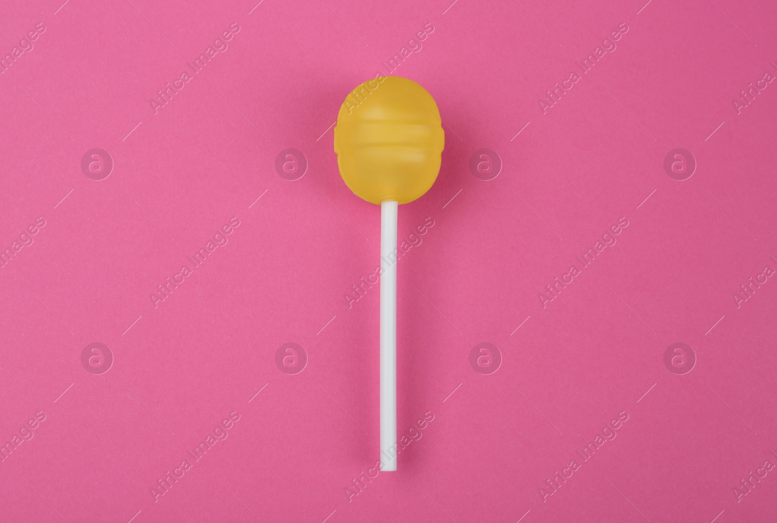 Photo of Tasty lemon lollipop on pink background, top view