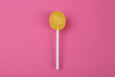 Tasty lemon lollipop on pink background, top view