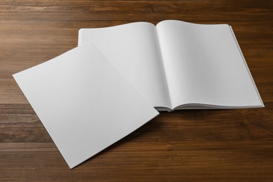 Photo of Sheet of paper and blank brochure on wooden table. Mockup for design