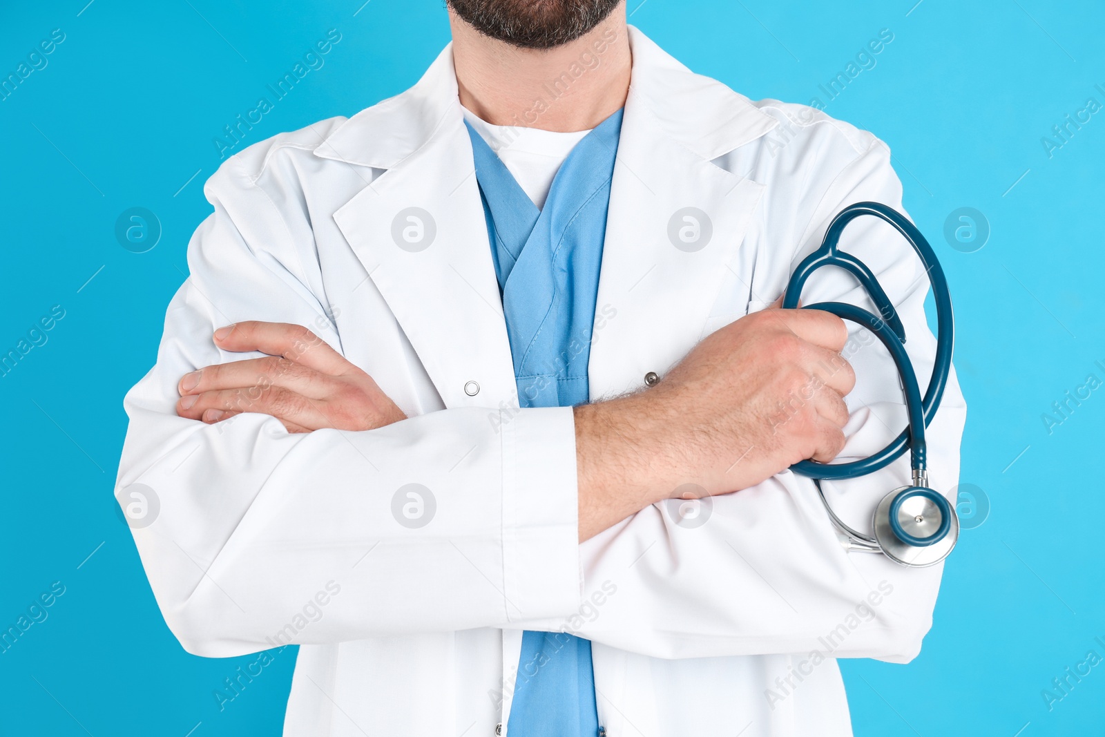 Photo of Mature doctor with stethoscope on blue background, closeup