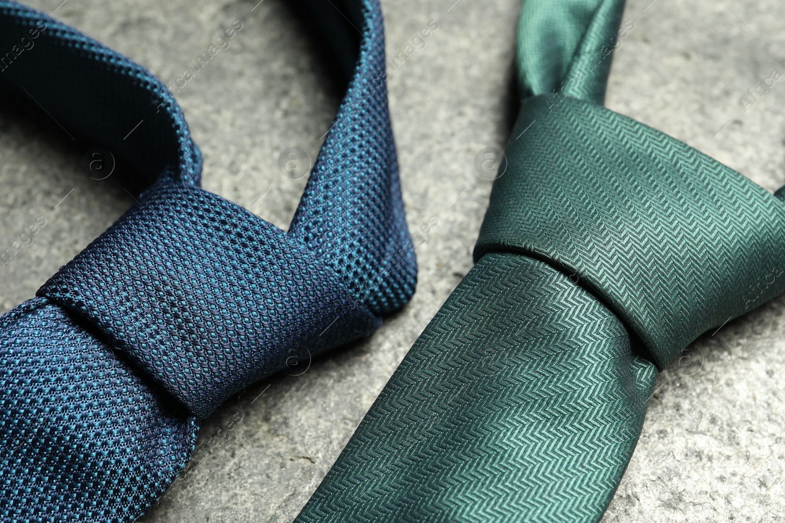 Photo of Two neckties on grey textured background, closeup