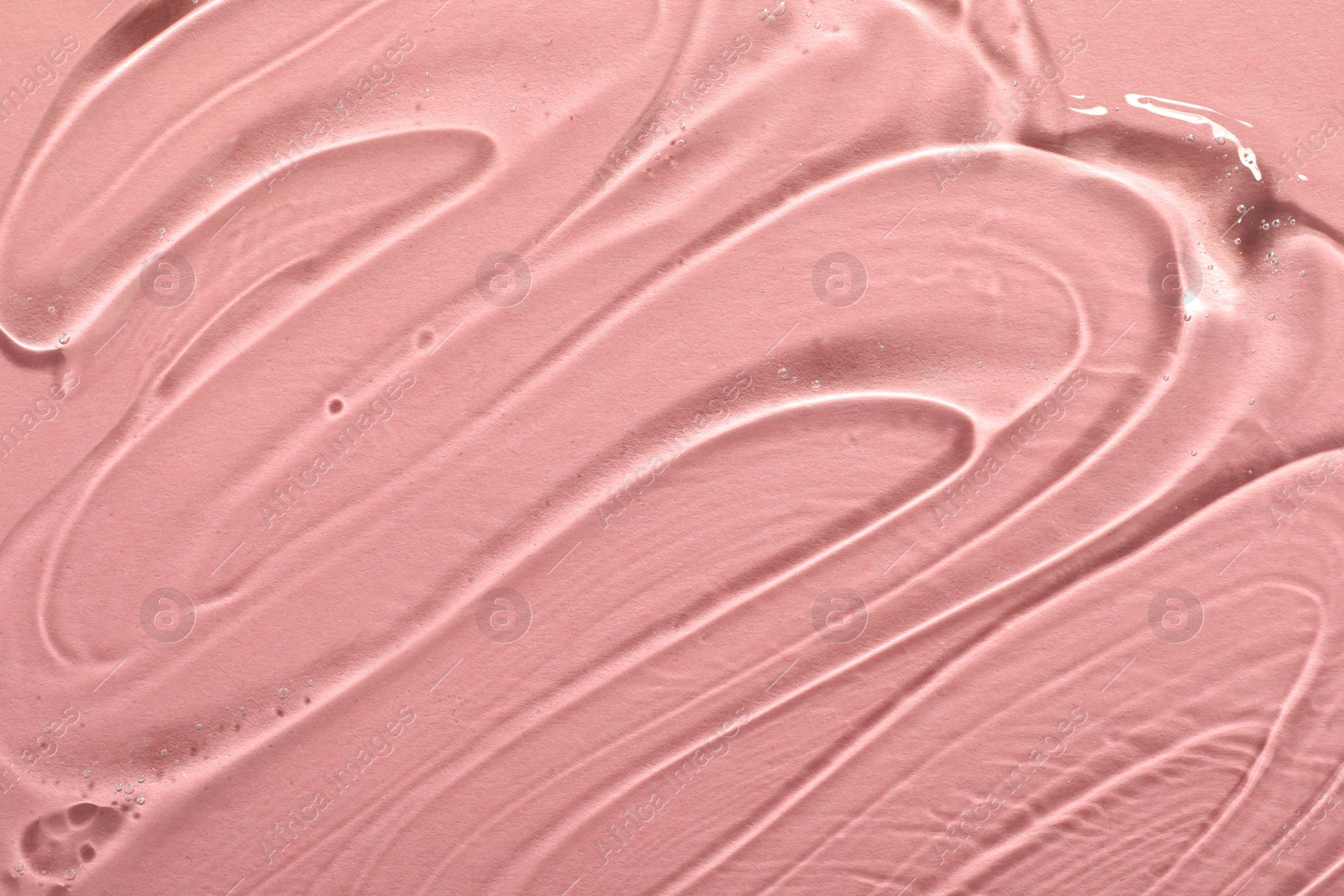 Photo of Transparent cosmetic gel on pink background, closeup view