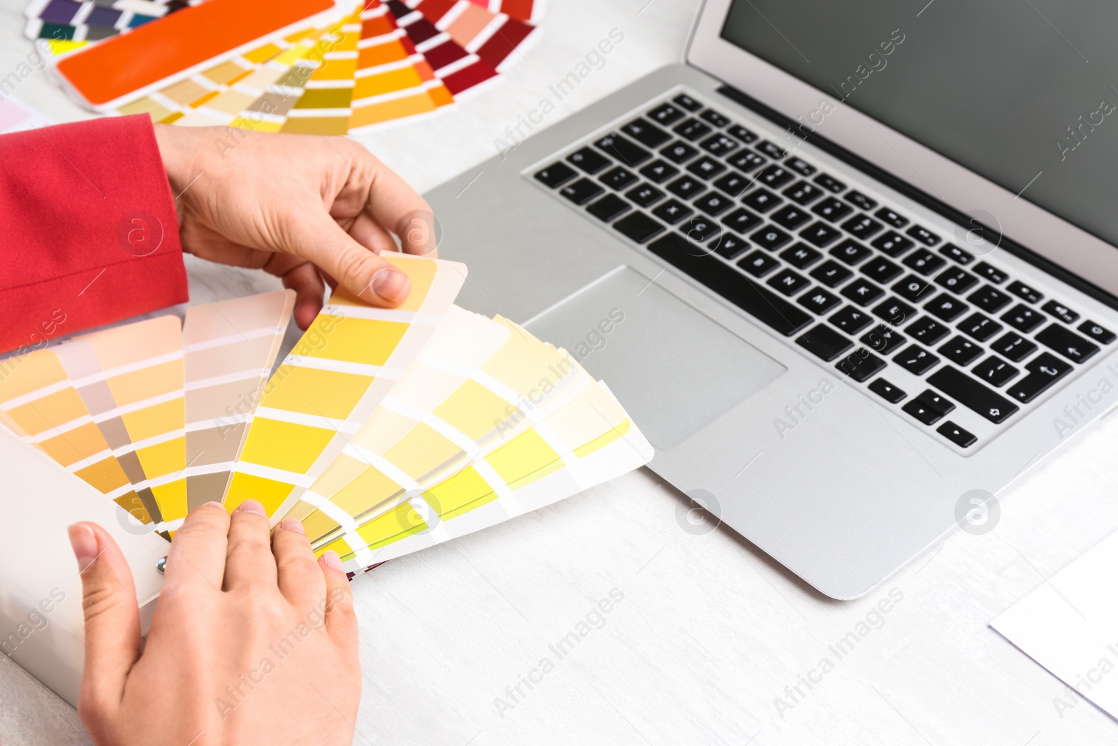 Photo of Woman with palette samples at white table, closeup