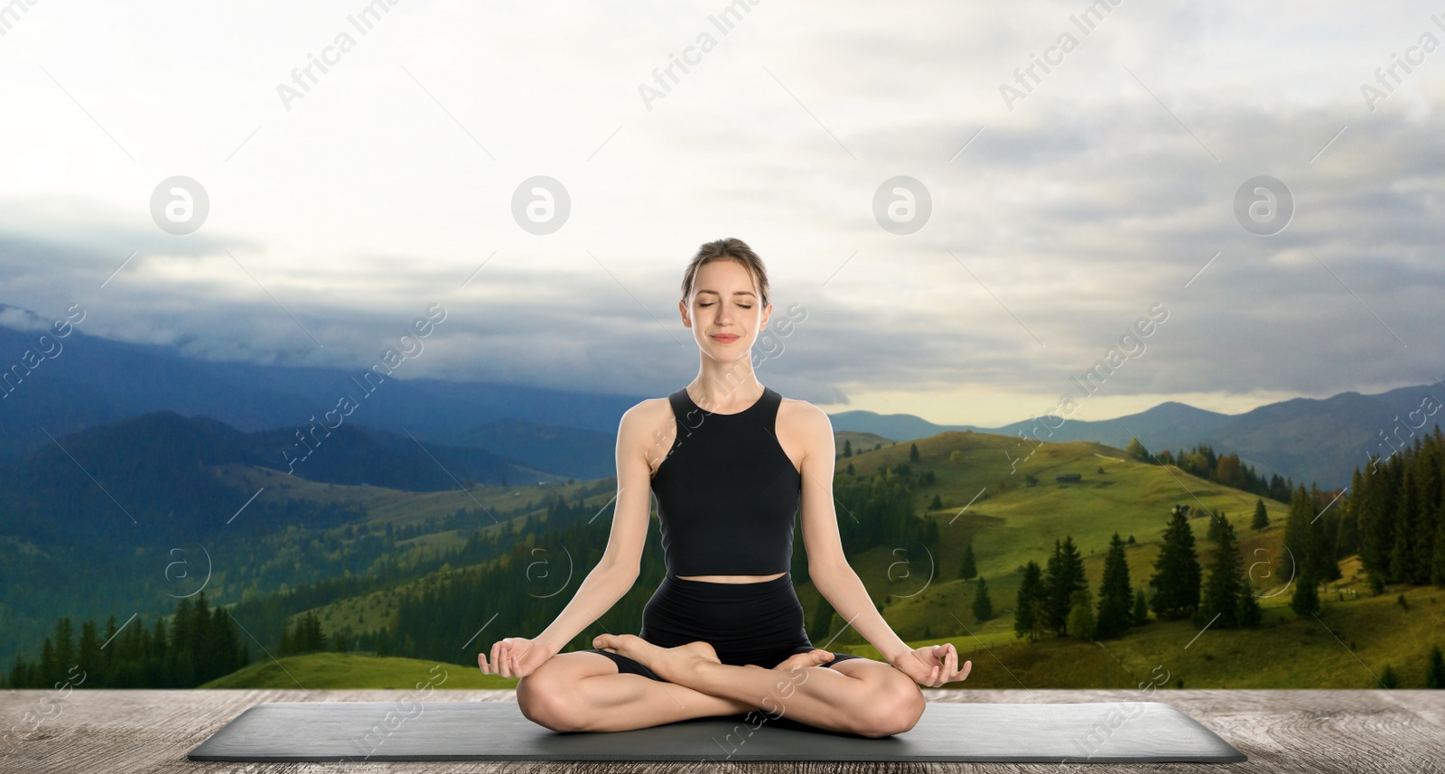 Image of Young woman practicing yoga on wooden surface against beautiful mountain landscape. Banner design