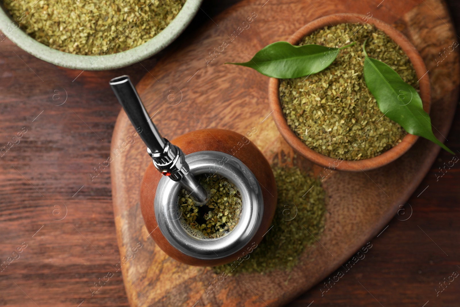 Photo of Calabash with mate tea and bombilla on wooden table, top view