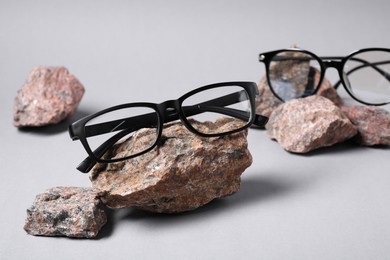 Photo of Different stylish glasses on stones against white background