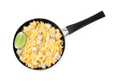Frying pan with delicious scrambled eggs, tofu and lime isolated on white, top view