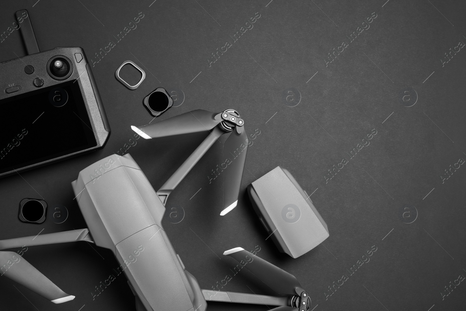 Photo of Modern drone with camera and video production equipment on black background, flat lay. Space for text