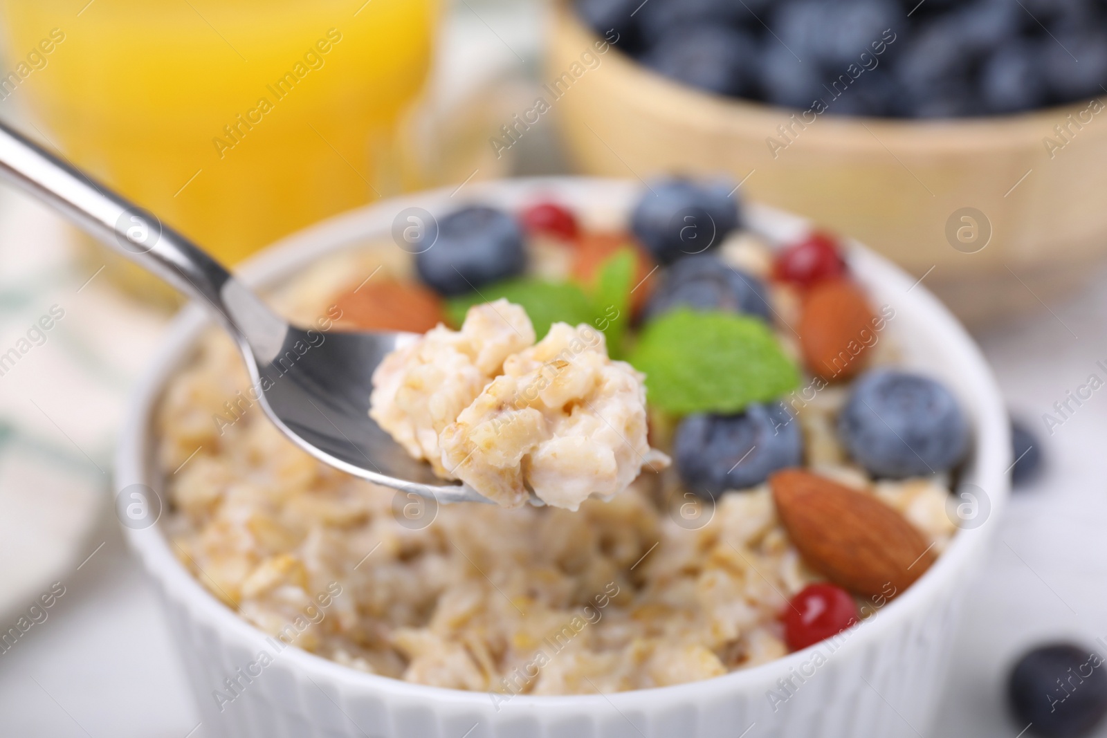 Photo of Spoon of oatmeal against blurred background, closeup