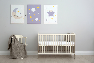 Photo of Baby room interior with crib and cute posters on wall