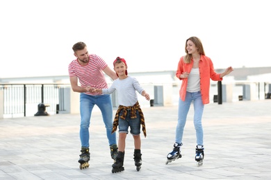 Happy family roller skating on city street