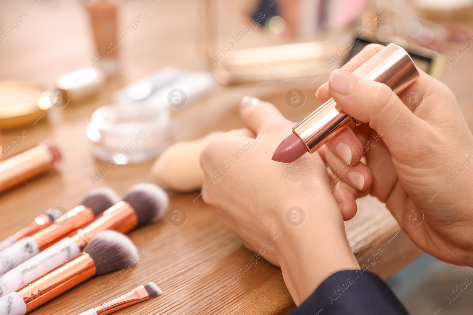 Photo of Beauty blogger doing lipstick swatch at table, closeup