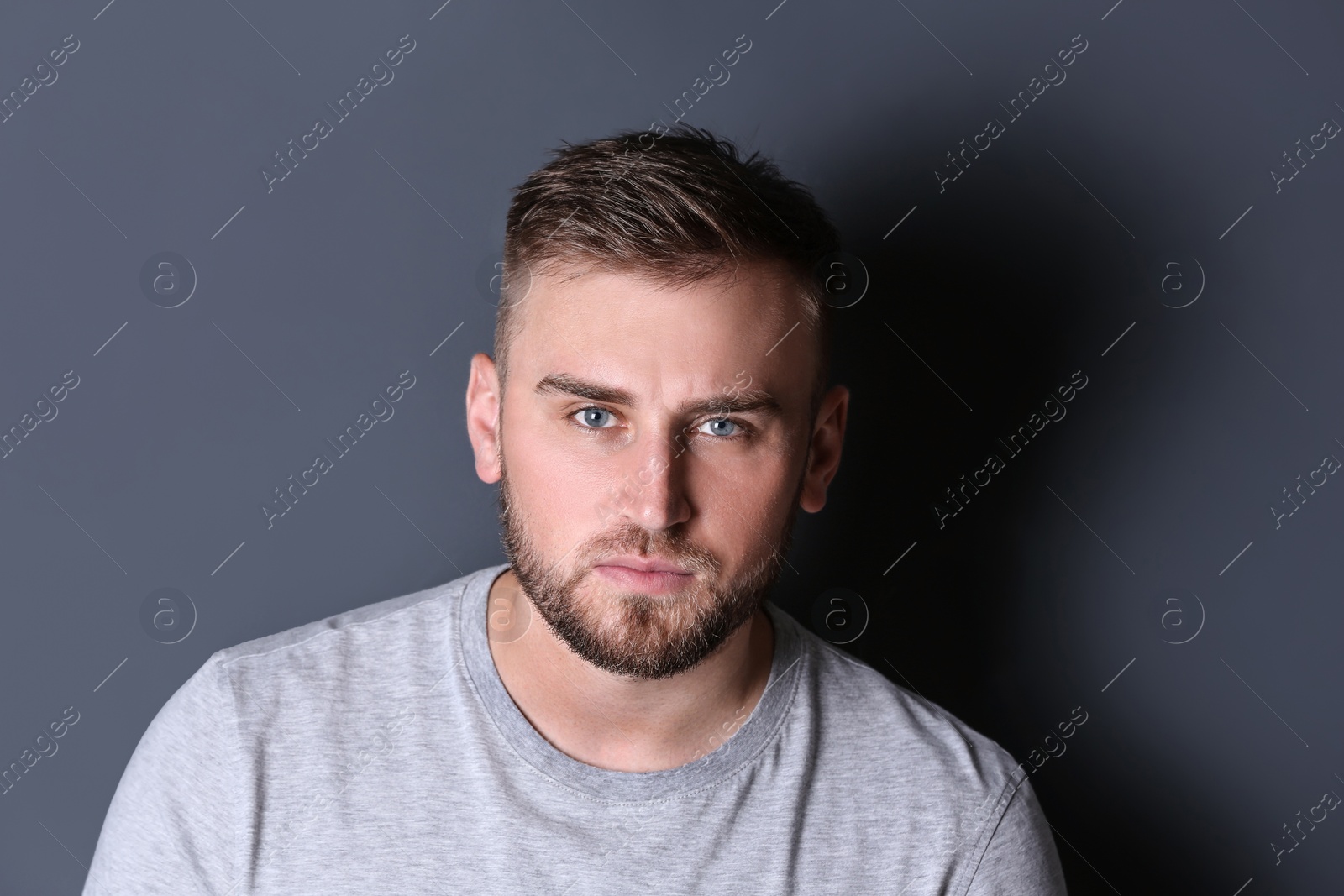 Photo of Portrait of handsome serious man on grey background