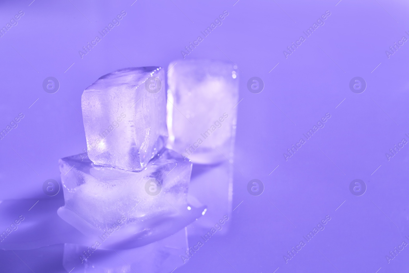 Photo of Ice cubes on color background. Space for text