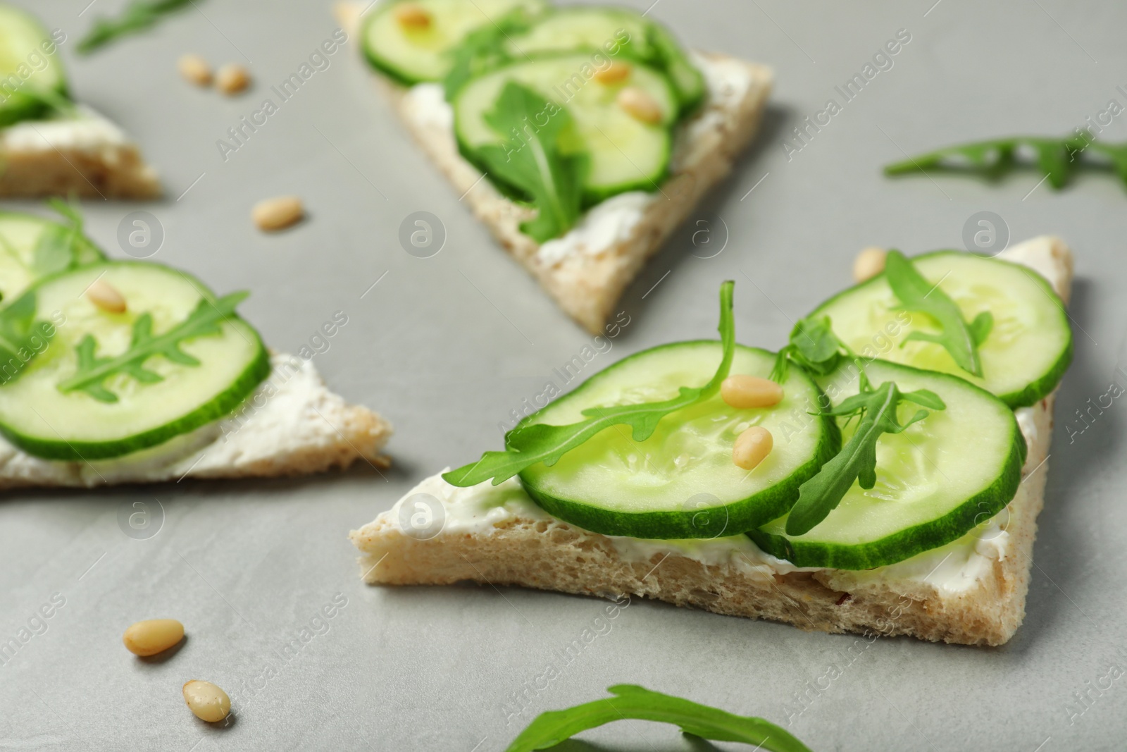 Photo of Traditional English cucumber sandwiches on grey table