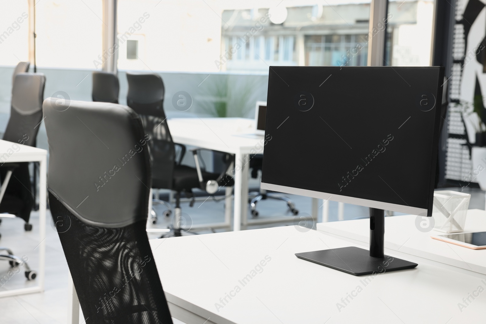 Photo of Workplace with tables and chairs in open plan office. Stylish interior