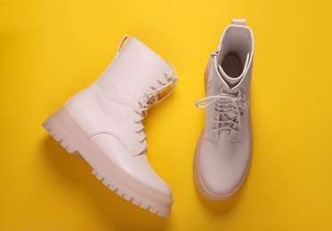 Pair of stylish shoes on yellow background, flat lay