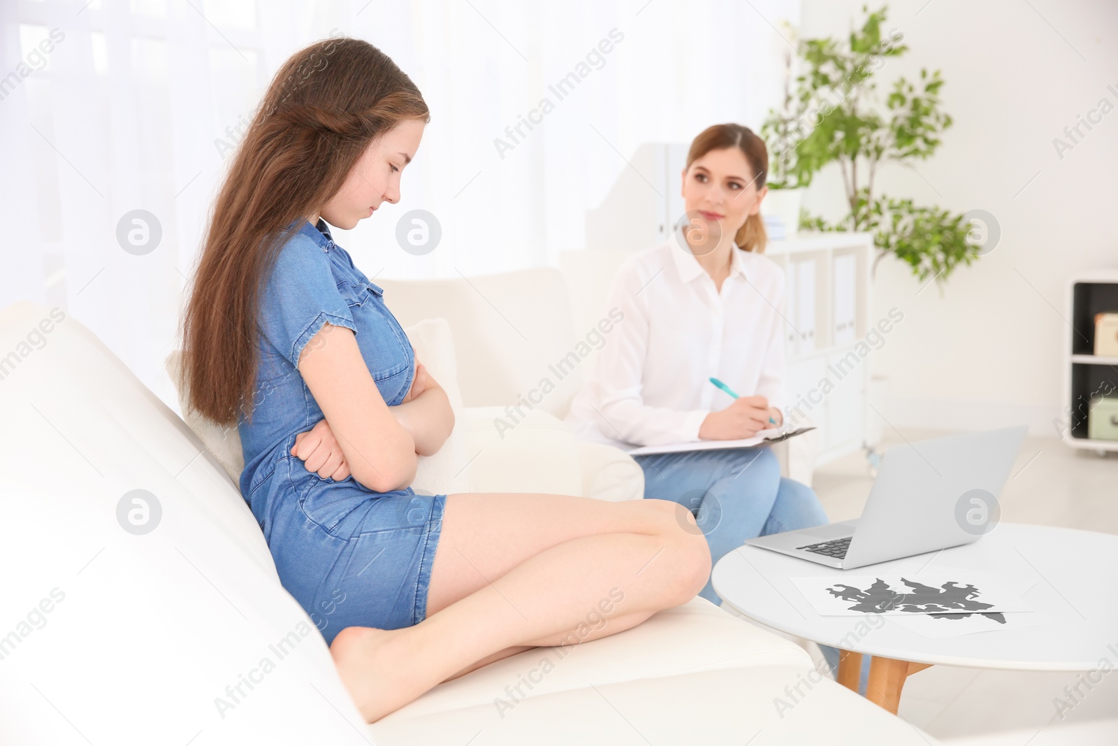 Photo of Female psychologist working with teenager girl in office