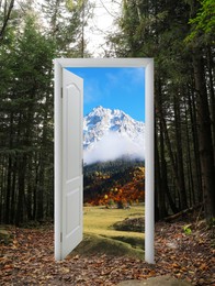 Image of Beautiful mountain landscape visible through open door amidst forest