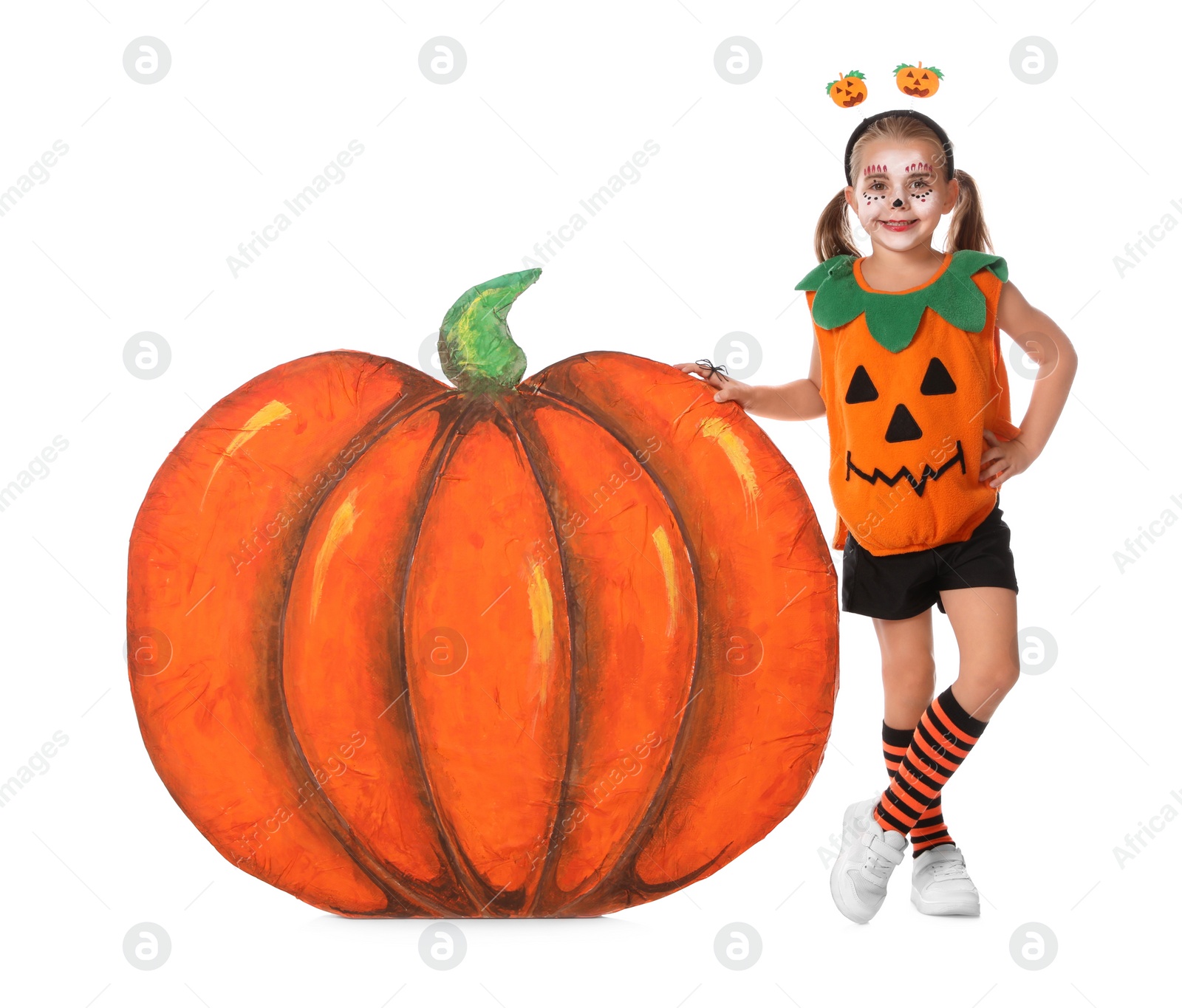 Photo of Cute little girl wearing Halloween costume and decorative pumpkin on white background