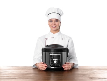 Female chef with modern multi cooker at table against white background