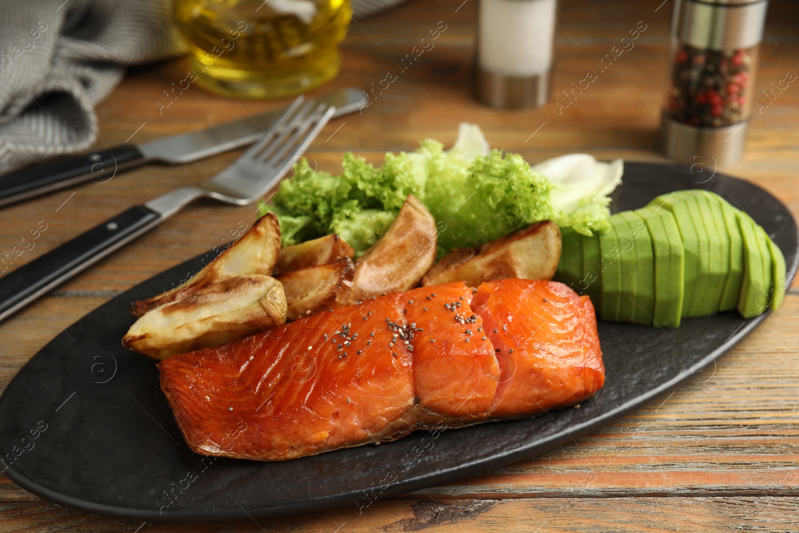 Photo of Tasty cooked salmon and vegetables served on wooden table. Healthy meals from air fryer