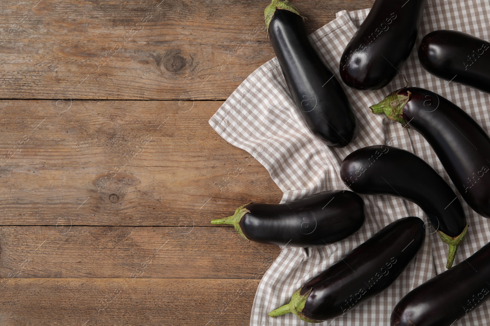 Photo of Raw ripe eggplants on wooden table, flat lay. Space for text