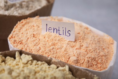 Photo of Sack with lentil flour on blurred background, closeup
