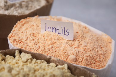 Sack with lentil flour on blurred background, closeup