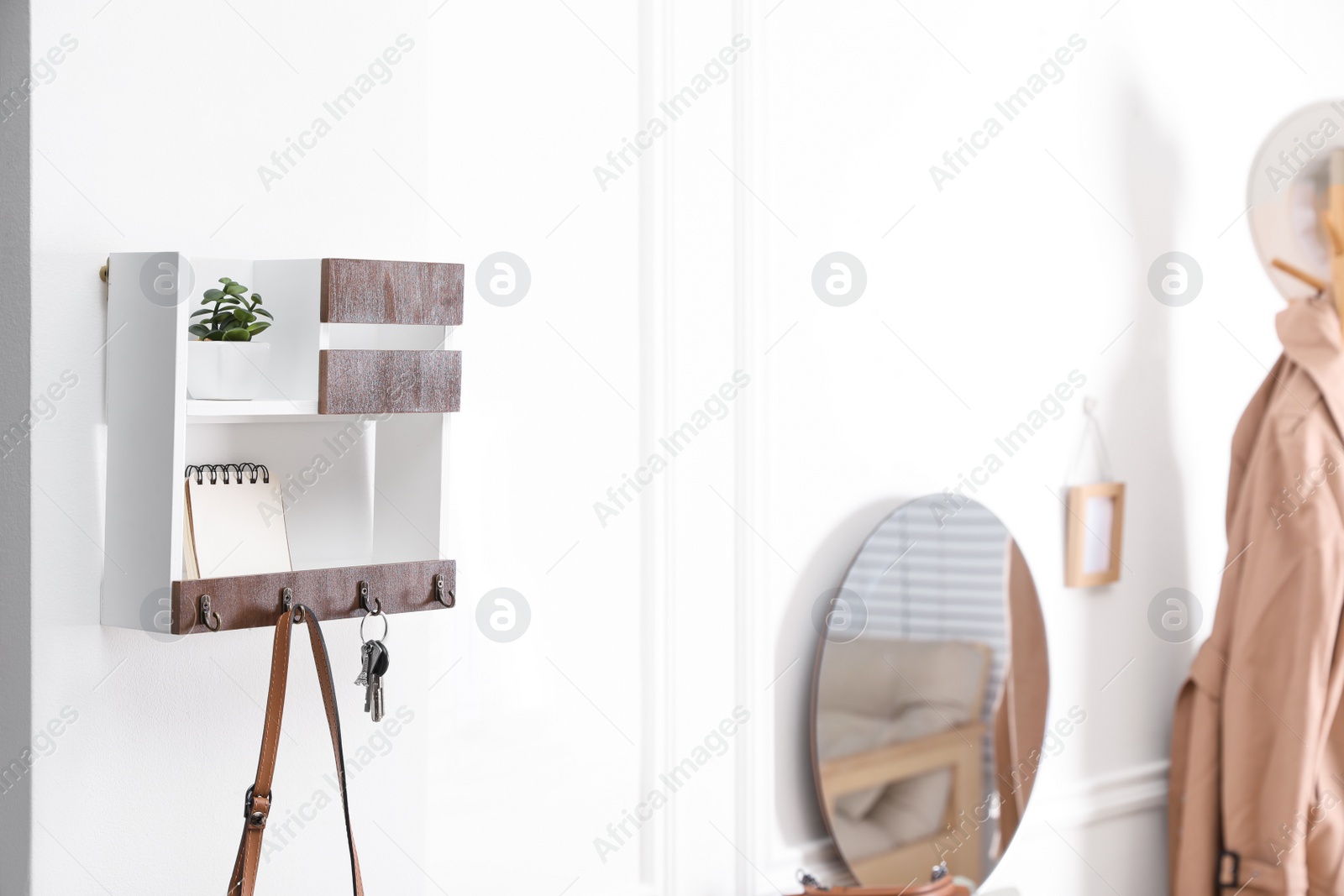 Photo of Wooden key holder on white wall in hallway