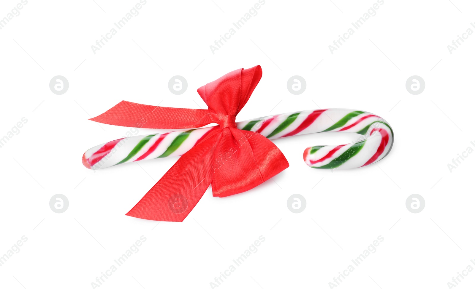 Photo of Sweet Christmas candy cane with red bow on white background