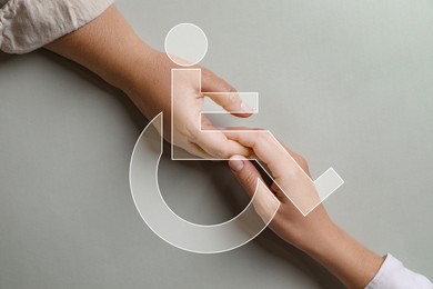 Inclusion concept. International symbol of access. Women holding hands on light grey background, top view