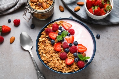 Tasty homemade granola with yogurt on grey table, flat lay. Healthy breakfast