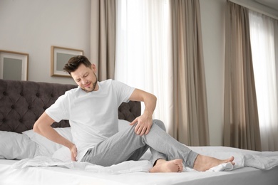 Photo of Man suffering from back pain in bedroom