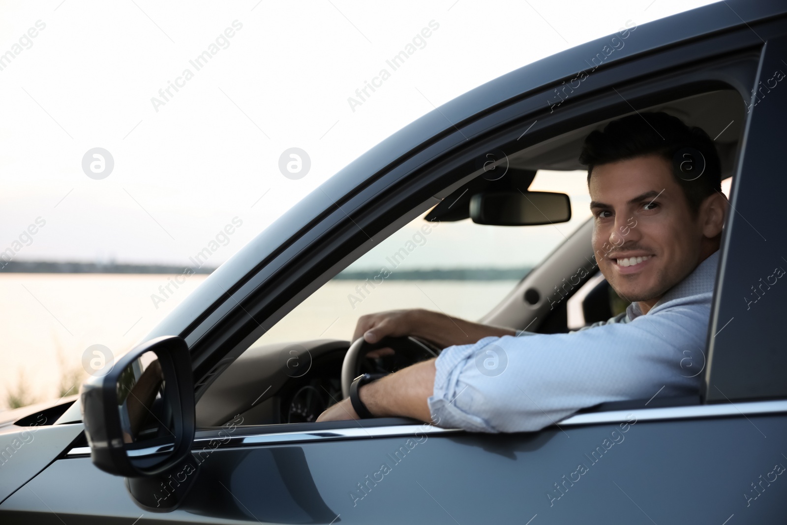 Photo of Handsome man in his modern car, view from outside