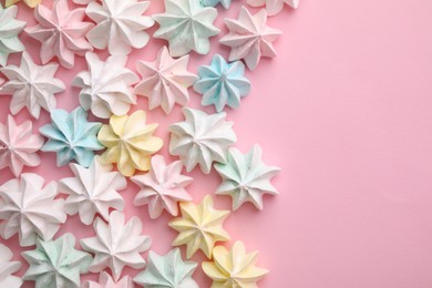 Photo of Many tasty meringue cookies on pink background, flat lay. Space for text