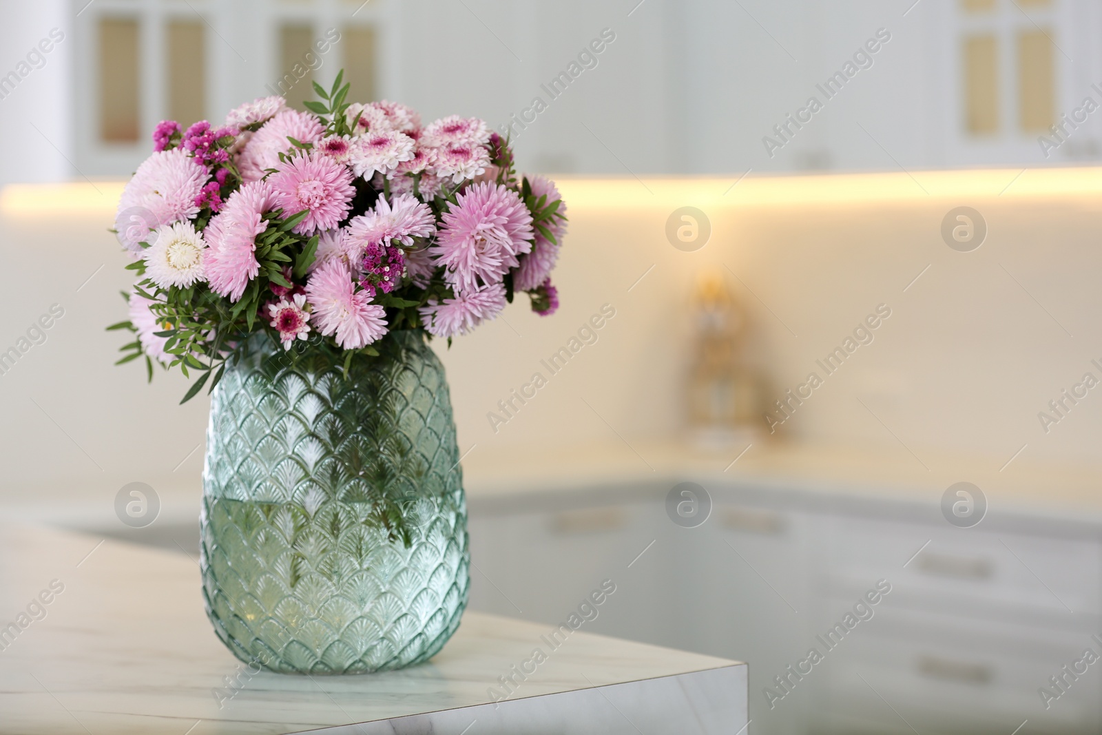 Photo of Vase with beautiful chrysanthemum flowers on table in kitchen, space for text. Interior design