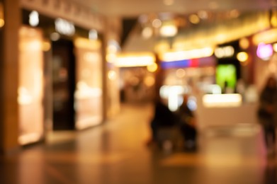 Photo of Blurred view of shopping mall with different stores, bokeh effect